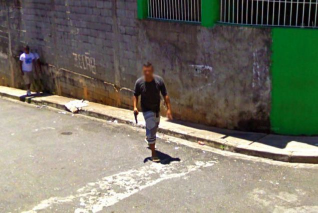 Hombre armado andando por la calle