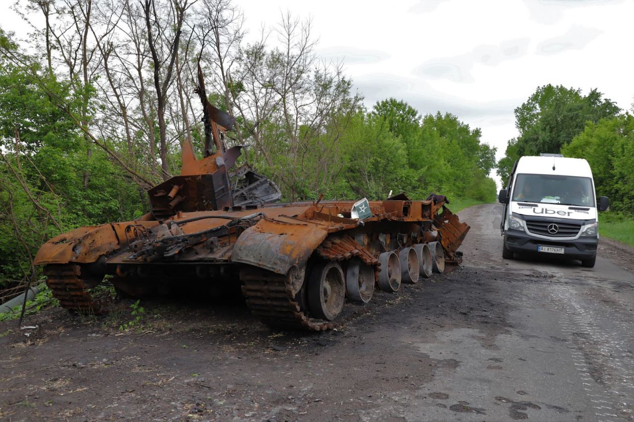 Una furgoneta de Uber Restore pasa junto a un tanque destruido en la carretera que atraviesa las zonas del este de Kiev, anteriormente ocupadas por las fuerzas rusas 
