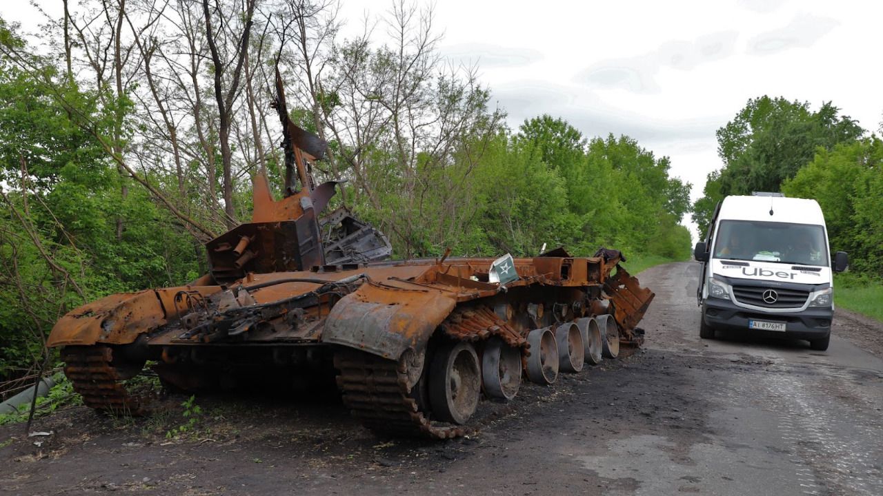 Una furgoneta de Uber Restore pasa junto a un tanque destruido en la carretera que atraviesa las zonas del este de Kiev, anteriormente ocupadas por las fuerzas rusas 