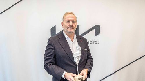 Eduardo Dívar, director general de Kia España, posa con el I Premio CarDesign.es al mejor diseño de coche eléctrico concedido al EV6