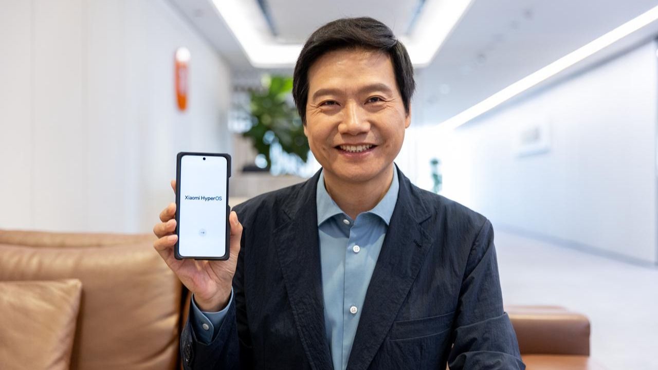 Lei Jun, fundador y CEO de Xiaomi, junto a un terminal con el logo del nuevo sistema operativo de la marca