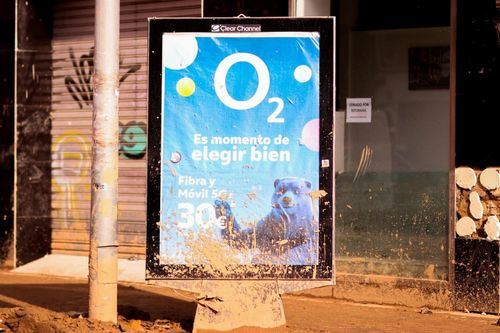 Un mupi muestra una publicidad del operador O2 cubierto de lodo tras el paso de la DANA en Valencia
