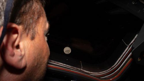 El comandante de la misión Artemis II y astronauta de la NASA, Reid Wiseman, contempla la Luna desde una de las ventanas principales de la cabina de la nave espacial Orión, antes del sobrevuelo lunar de la tripulación el 6 de abril de 2026