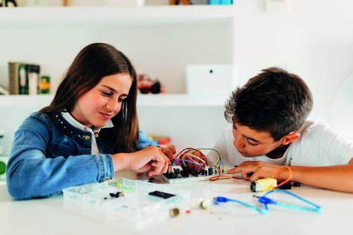 Una niña y un niño aprenden robótica con los productos de Ebotics
