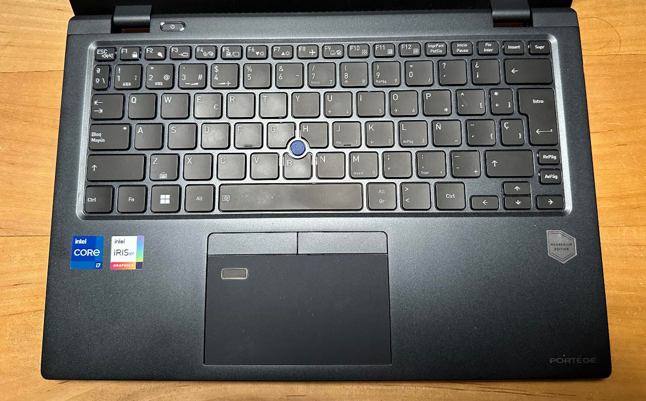 El teclado es completo, con las teclas suficientemente separadas y de buen recorrido. El trackpad no es de los mayores, pero cumple su función. En el centro del teclado, en azul, está el botón para controlar el cursor. 