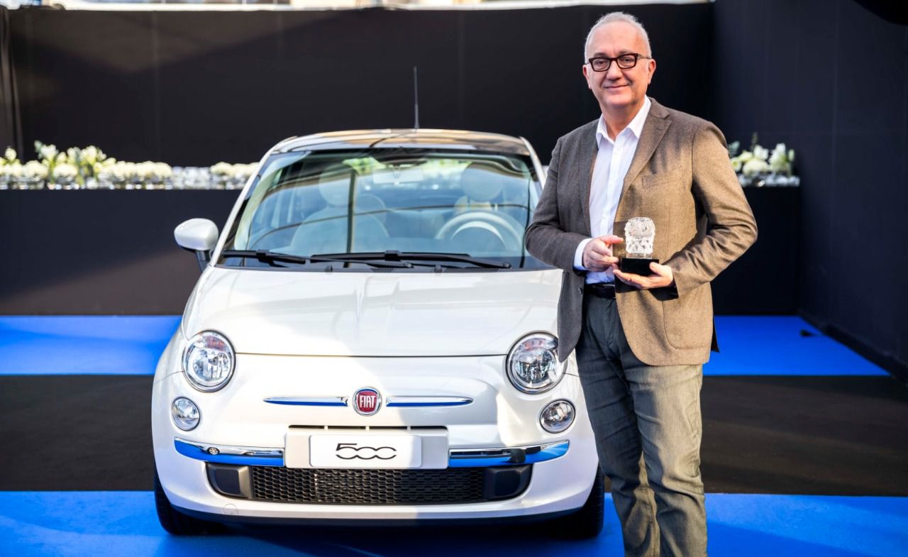 Roberto Giolito con su galardón junto a su creación más representativa, el modelo Fiat 500