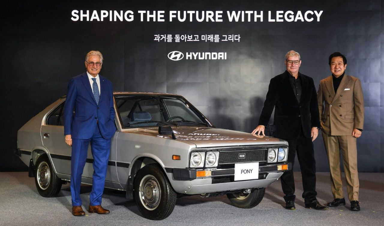 Modelo clásico icónico Hyundai Pony junto con los diseñadores Giorgetto Giugiaro, Luc Donckerwolke y Sang Yup Lee
