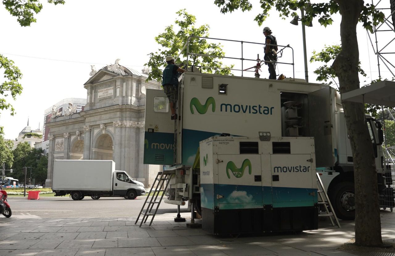 Operarios instalando una unidad móvil de Telefónica en la Puerta de Alcalá